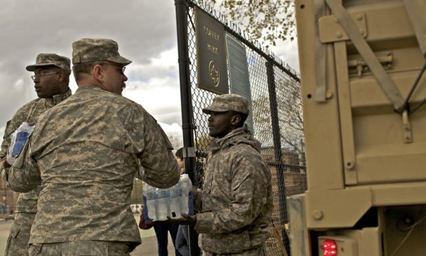 Members of the National Guard unload food and water for distribution at Cofey Park in Red Hook, Brooklyn Friday. Members of the National Guard unload food and water for distribution at Cofey Park in Red Hook, Brooklyn Friday.