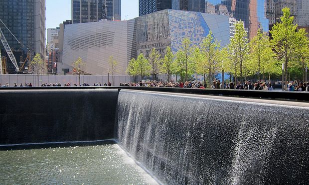 The National September 11 Memorial Museum, which remains unopened, rises behind a reflecting pool at The World Trade Center