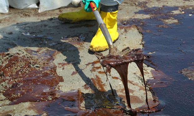 A BP cleanup crew shovels oil from a beach on May 24, 2010 at Port Fourchon, Louisiana. BP CEO Tony Hayward, who visited the beach, said that BP is doing everything possible to clean up the spill.