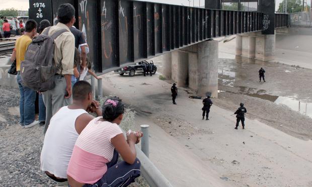 Police officers stand next to the body of young Mexican migrant Sergio Adrian Hernández (14), at the US/Mexico border, under the 'Santa Fe International Cross' gate, in Ciudad Juarez, Mexico. (June 7)