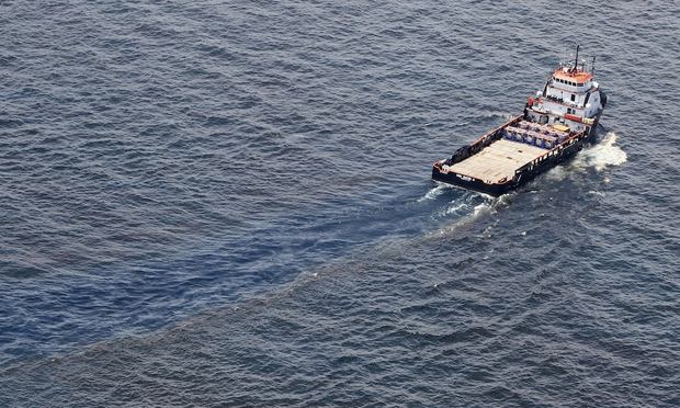 A ship passes through oil covered water near the site of the Deepwater Horizon oil spill on June 19, 2010 in the Gulf of Mexico off the coast of Louisiana.