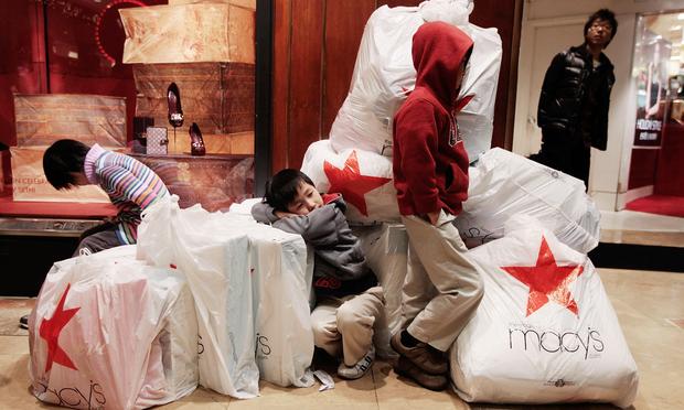 Children wait with shopping bags inside Macy's department store on 'Black Friday.'
