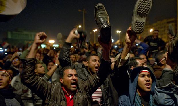 Egyptian anti-government demonstrators wave their shoes as they show their anger during a speech by Egyptian President Hosni Mubarak, who failed to announce his immediate resignation.