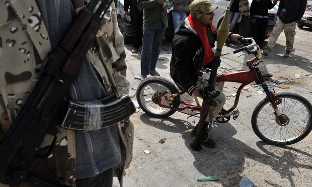 ibyan rebels wait at a checkpoint in Brega, 240 kms (150 miles) south of Benghazi, on March 30, 2011