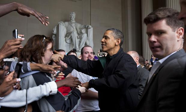 President Barack Obama shakes the hands of tourists visiting the Lincoln Memorial during a surprise visit a day after budget negotiations with Congress prevented a government shutdown April 9, 2011