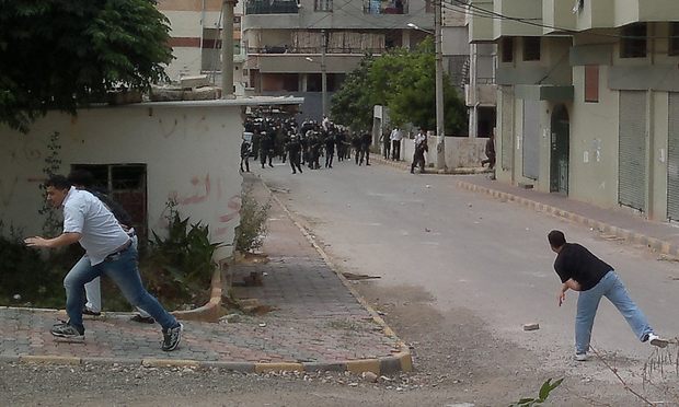 Men throw stones at riot police during clashes in the Mediterranean coastal town of Banias, on May 27, 2011, as Syria braced for more anti-government protests, called for by pro-reform activists.