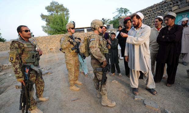 US soldiers of the Viper Company (Bravo), 1-26 Infantry, talk to Afghan men as they conduct a house to house search operation for weapons in the Khost province of eastern Afghanistan on June 19, 2011.