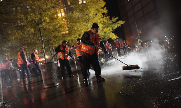 Workers clean up Zuccotti Park after New York City police in riot gear removed Occupy Wall Street protesters early on November 15, 2011 in New York.