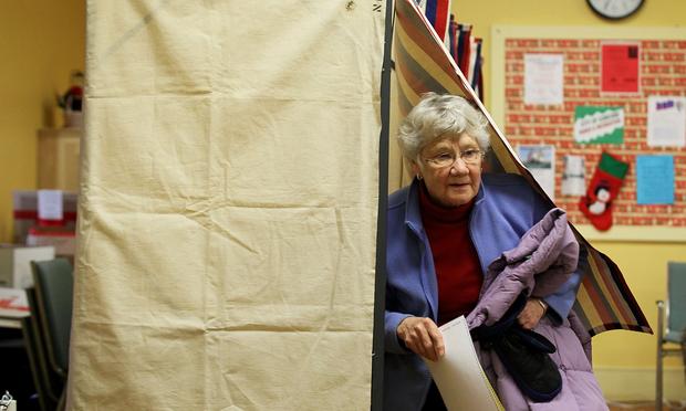 Voter Julie Runnells comes out from a voting booth at a polling station in Concord, NH. Local voter Julie Runnells comes out from a voting booth at a polling station January 10, 2012 in Concord, New Hampshire