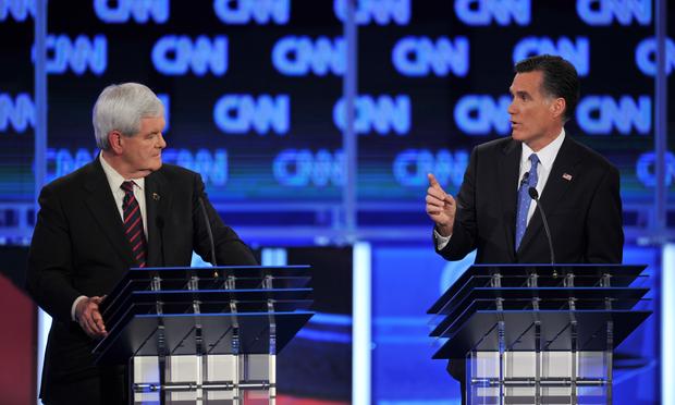 Republican presidential candidates Newt Gingrich listens to former Massachusetts governor Mitt Romney.