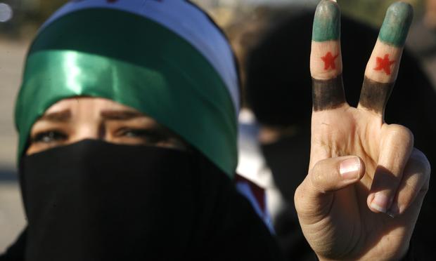 A woman flashes the V for 'victory' sign in protest against the Syrian regime.
