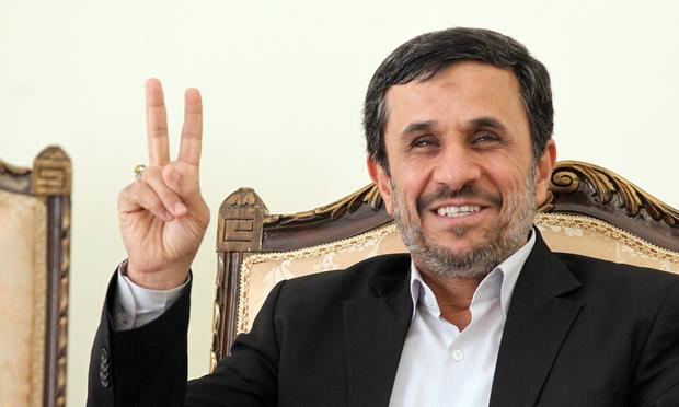 Iranian President Mahmoud Ahmadinejad flashes the V-sign for victory as he waits for the arrival of Ismail Haniya, Palestinian Hamas premier.
