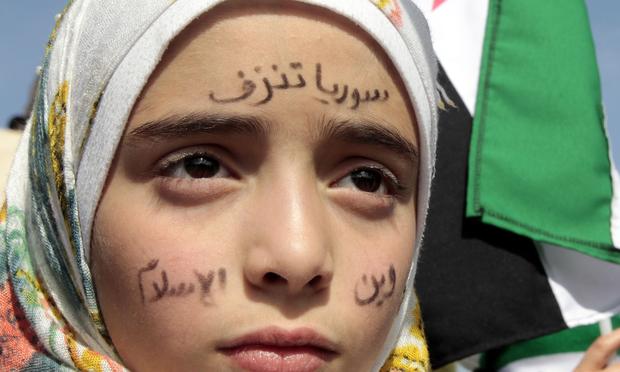 Syrians rally outside the US Embassy in Amman to demand a US military intervention.