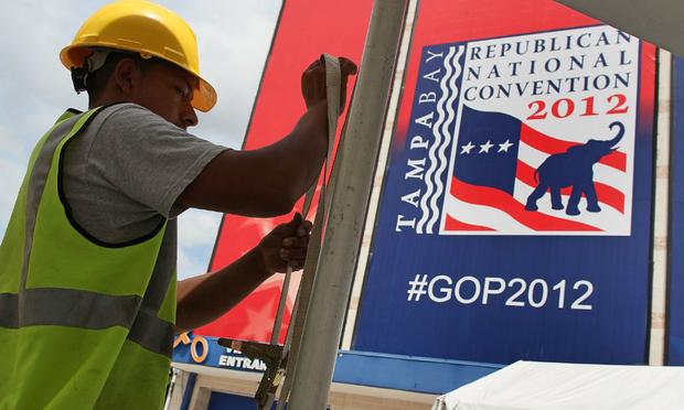 A worker secures a tent for the Republican National Convention at Tampa Bay Times Forum as the region prepares for Tropical Storm Isaac.