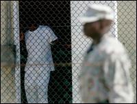 A Guantanamo detainee stands in the doorway of his cell.