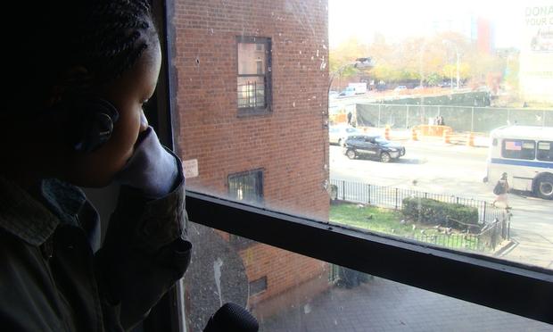Temitayo Fagbenle looks out the window of a public housing building