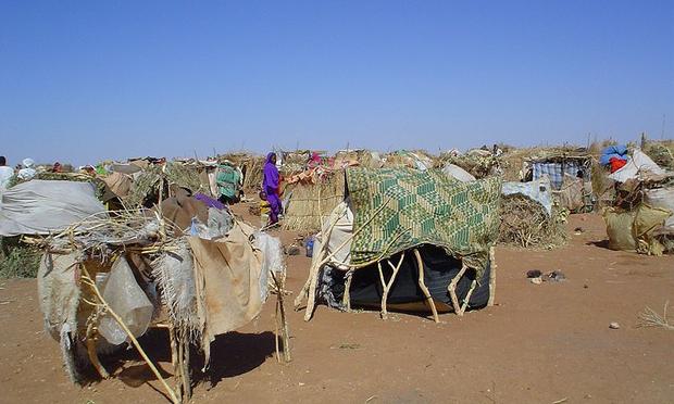 Internally Displaced Persons (IDPs) use sticks and scraps of plastic to construct makeshift shelters at Intifada transit camp near Nyala in South Darfur.