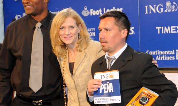 Chilean miner Edison Pena (right) receives a racing bib and a racing watch for Sunday's marathon from New York Road Runners president Mary Wittenberg and former New York Giants player Amani Toomer.