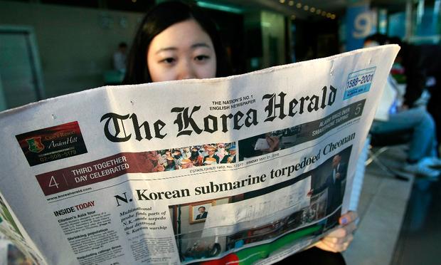 A South Korean woman reads a newspaperin Seoul, South Korea.
