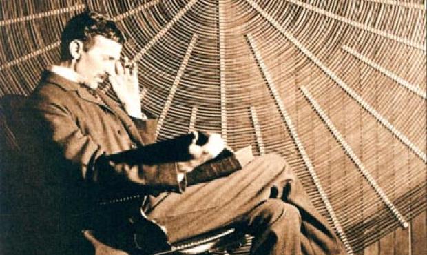 Nikola Tesla, with Rudjer Boscovich's book 'Theoria Philosophiae Naturalis', in front of the spiral coil of his high-frequency transformer at East Houston St., New York Studio 360 Episode 948, Nikola Tesla: Strange Genius