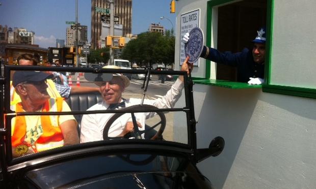 Former NYC traffic commissioner Sam Schwartz hands a symbolic 1911 dime to a 'toll taker' on the Manhattan side of the Williamsburg Bridge.