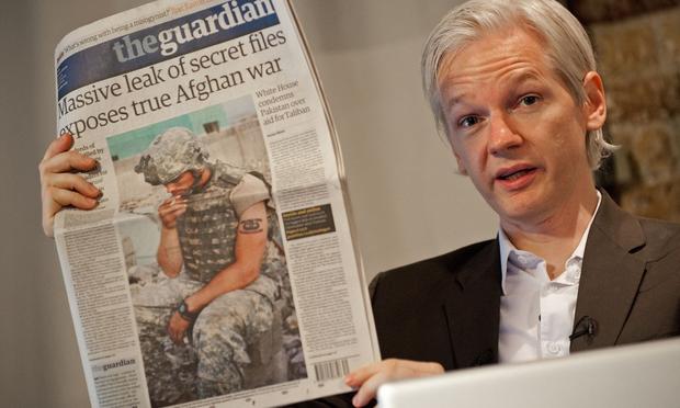 WikiLeaks Founder Julian Assange holds a copy of today's Guardian newspaper