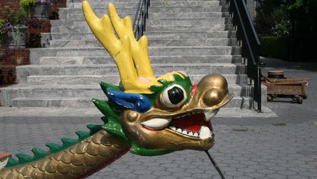 A closer look at the boat's bow reveals a detailed dragon head. A closer look at the boat's bow reveals a detailed dragon head and tail.