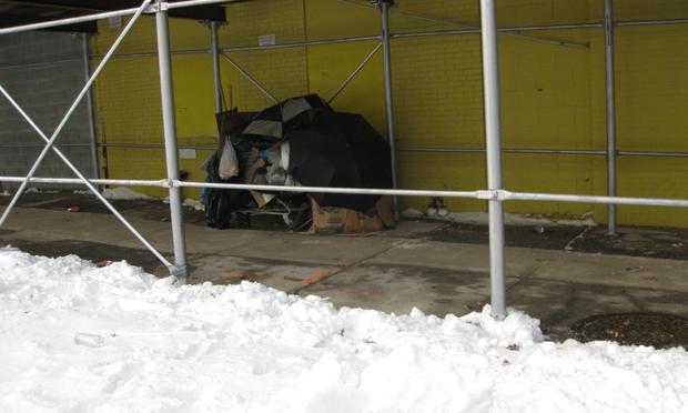 A homeless woman in Prospect Heights, Brooklyn builds a makeshift shelter from the snow.