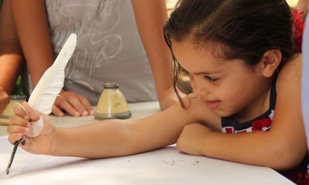 Jazz Caruso, quill in hands, signs her John Hancock on a copy of the Declaration.