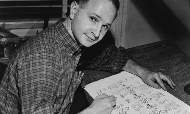 Jules Feiffer, American cartoonist, seated at work on cartoon.