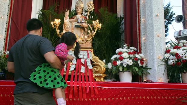 Visitors leave money for charity at the statue of San Gennara at the Most Precious Blood Church on Mulberry Street in Little Italy.