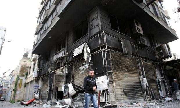 A man walks past a burnt-out building in the Northern city of Latakia, some 350 km northwest Damascus on March 27, 2011. A man walks past a burnt-out building in the Northern city of Latakia, some 350 km northwest Damascus on March 27, 2011.