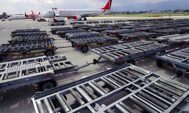 Cargo trolleys are parked on the tarmac at Cointrin Geneva's International Airport, on April 18, 2010 as planes are grounded following the volcanic eruption in Iceland.