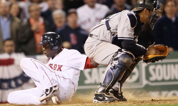 Mike Cameron #23 of the Boston Red Sox slides home safely past Jorge Posada #20 of the New York Yankees on April 4, 2010 during Opening Night at Fenway Park in Boston