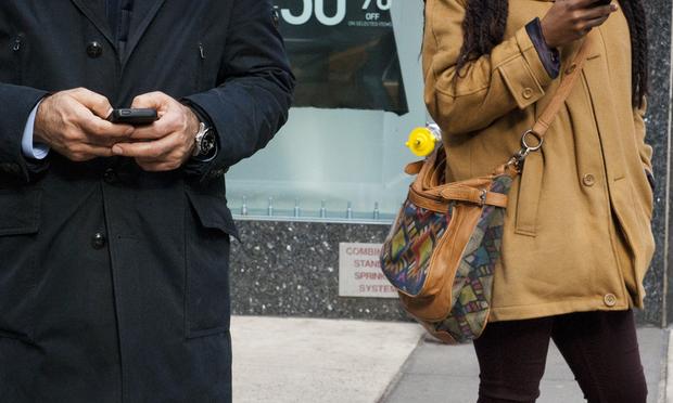 New Yorkers check their smartphones in midtown Manhattan on a cold day in January.