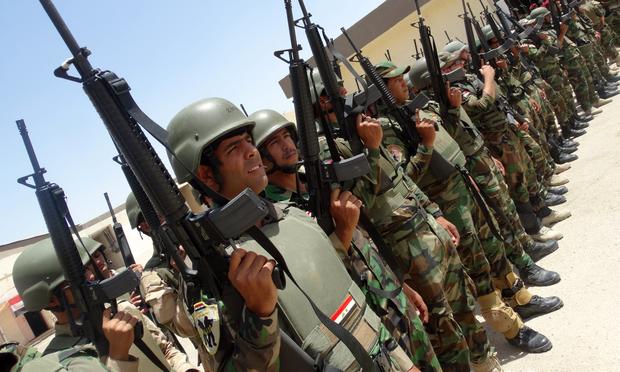 Iraqi troops stand in rows holding their weapons as they arrive to support the Sunni anti-Al-Qaeda militia Sahwa in its fight against anti-government militants. June 21, 2014