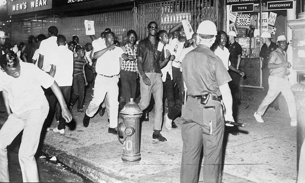 During the Harlem Riots of 1964, protesters march down 125th street with photographs of Lieutenant Thomas Gilligan.