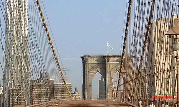 A mysterious white flag flies above the Brooklyn Bridge Tuesday morning