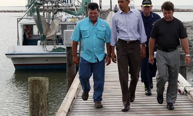 U.S. President Barack Obama is greeted by Mayor David Camardelle (R) of Grand Isle and Chris Camardelle (L) in Grand Isle, Louisiana, during his third visit to the state, June 4, 2010