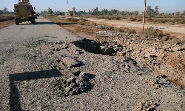 A massive IED crater by the road. Taken during a clearing operation south of Baghdad.