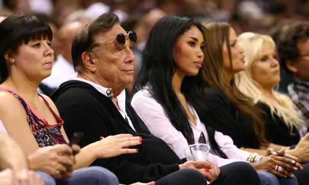 Donald Sterling, owner of the Los Angeles Clippers, sits next to his girlfriend V. Stiviano (R) during the 2013 NBA Playoffs at AT&T Center on May 19, 2013 in San Antonio, Texas.