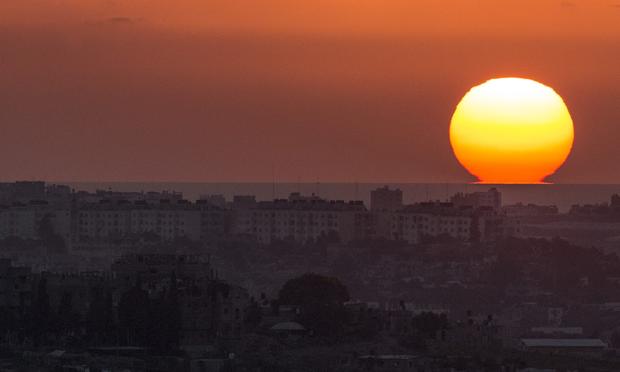 A picture taken from the southern Israeli Gaza border shows the sun setting over the Gaza strip