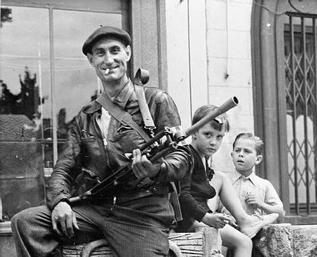 Watched by two small boys, a member of the French resistance (French Forces of the Interior) poses with his Bren gun at Chateaudun in 1944.