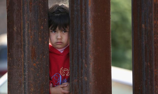 A child on the Mexican side of the U.S.-Mexico border fence looks into Arizona during a special 'Mass on the Border' on April 1, 2014 in Nogales, Arizona.