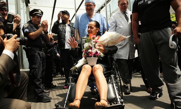 NYPD Officer Rosa Rodriguez is cheered by dozens of fellow officers as she is wheeled out of Weill Cornell Medical Center on May 19, 2014.