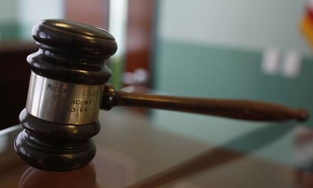 A judges gavel rests on top of a desk in the courtroom