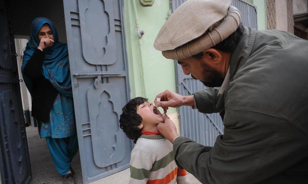A Pakistani health worker administers a polio vaccination to a child during a polio immunisation campaign in Peshawar on February 2, 2014. Pakistan polio vaccine