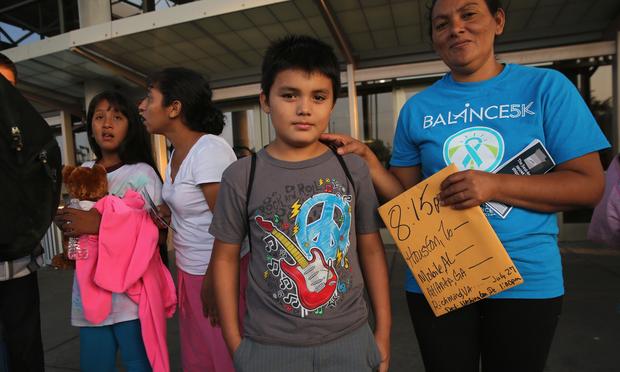 A Salvadorian family waits at the Greyhound bus station for their trip to Houston on July 25, 2014 in McAllen, Texas.