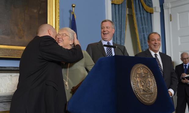 Schools Chancellor Carmen Farina hugging UFT President Michael Mulgrew as Mayor Bill de Blasio announced the teachers contract that included buy-outs for employees without permanent positions