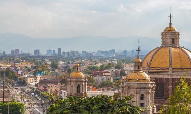 Old Basilica of Guadalupe with Mexico City skyline behind it Old Basilica of Guadalupe with Mexico City skyline behind it